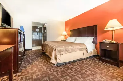 a hotel room with a bed and a flat screen tv at Quality Inn & Suites Lawrenceburg in Lawrenceburg