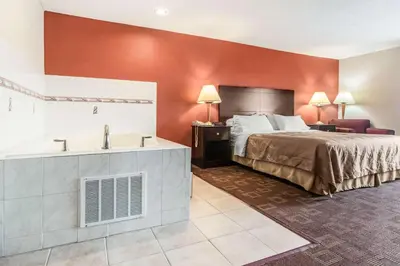 a hotel room with a bed and a bathroom at Quality Inn & Suites Lawrenceburg in Lawrenceburg