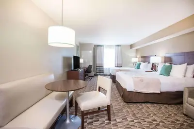 a hotel room with two beds and a table at Hawthorn Extended Stay by Wyndham Saint Clairsville in Saint Clairsville