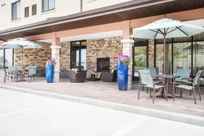 a patio with chairs and tables and umbrellas at Hawthorn Extended Stay by Wyndham Saint Clairsville in Saint Clairsville