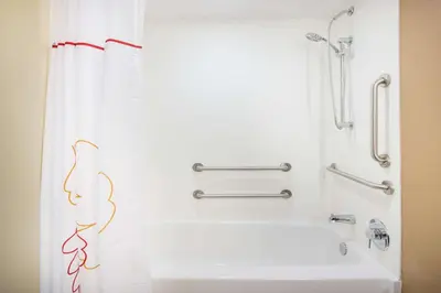 a bathroom with a tub and a shower curtain at Hawthorn Extended Stay by Wyndham Saint Clairsville in Saint Clairsville