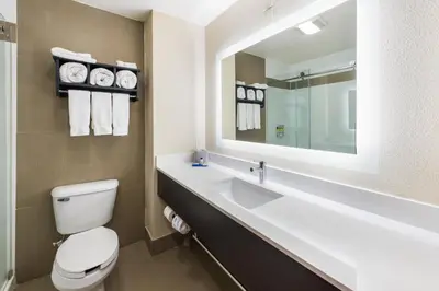 a bathroom with a toilet and a sink with a mirror at Holiday Inn Express London-I-70 by IHG in London