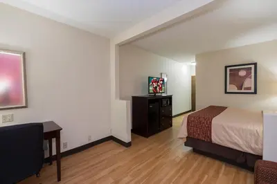 a hotel room with a bed and a flat screen tv at Red Roof Inn & Suites Cincinnati North-Mason in Mason