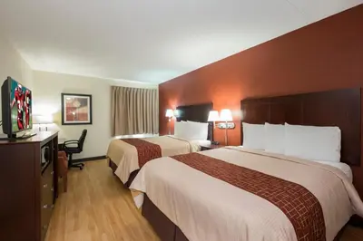 a hotel room with two beds and a flat screen tv at Red Roof Inn & Suites Cincinnati North-Mason in Mason