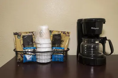 a coffee maker and a basket on a table at Red Roof Inn & Suites Cincinnati North-Mason in Mason