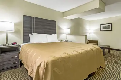 a hotel room with a large bed and a chair at Quality Inn & Suites North Lima - Boardman in North Lima