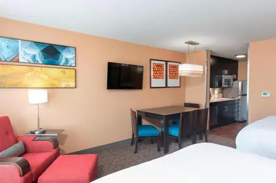 a hotel room with a bed and a dining room at TownePlace Suites by Marriott Ontario-Mansfield in Mansfield