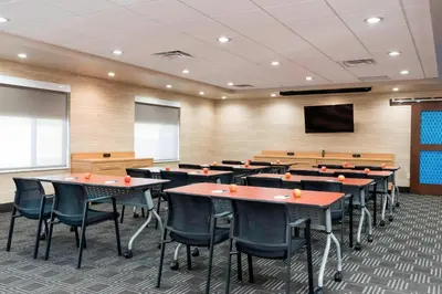a conference room with tables and chairs and a screen at TownePlace Suites by Marriott Ontario-Mansfield in Mansfield