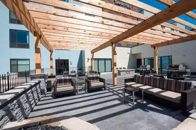 a patio with chairs and a wooden pergola at TownePlace Suites by Marriott Ontario-Mansfield in Mansfield