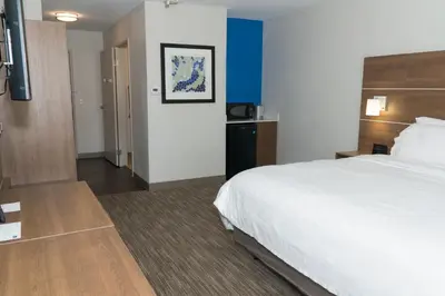 a hotel room with a large bed and a bathroom at Holiday Inn Express Hotel & Suites Madison by IHG in Madison