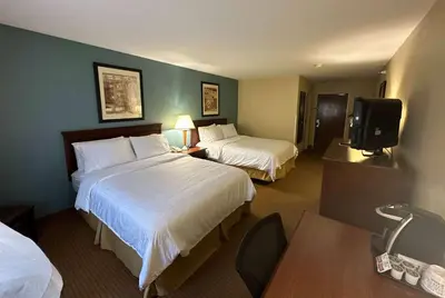 a hotel room with two beds and a tv at Wingate by Wyndham Newell in Newell