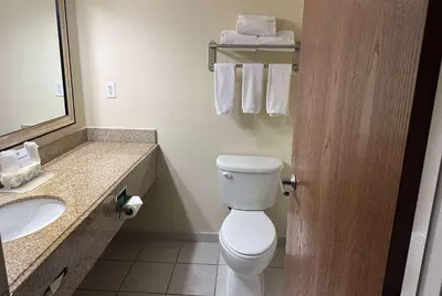 a bathroom with a toilet and a sink and a mirror at Wingate by Wyndham Newell in Newell