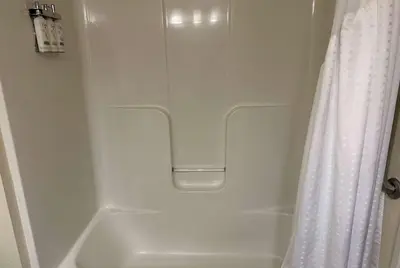 a bathroom with a shower curtain and a white tub at Wingate by Wyndham Newell in Newell