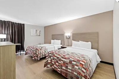 a hotel room with two beds and a desk at Red Roof Inn Cambridge, OH in Cambridge