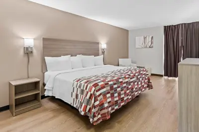 a hotel room with a large bed and a window at Red Roof Inn Cambridge, OH in Cambridge