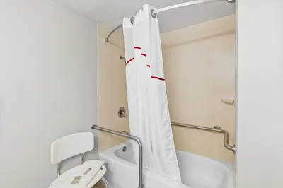 a bathroom with a shower curtain and a toilet at Red Roof Inn Cambridge, OH in Cambridge