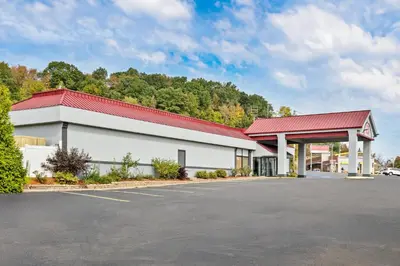 a building with a red roof and a parking lot at Red Roof Inn Cambridge, OH in Cambridge
