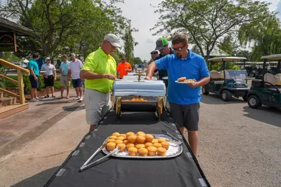 a group of men standing around a table with food at Sawmill Creek by Cedar Point Resorts in Sandusky