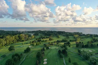 an overhead view of a golf course with the ocean in the background at Sawmill Creek by Cedar Point Resorts in Sandusky