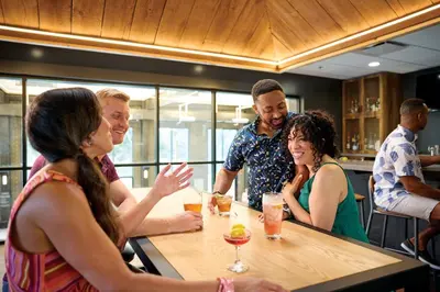 a group of people sitting around a table in a restaurant at Sawmill Creek by Cedar Point Resorts in Sandusky