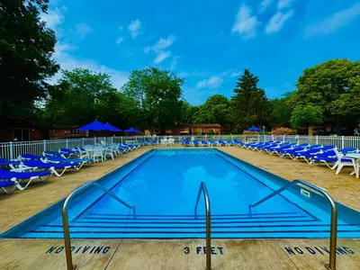 a swimming pool with blue chairs and blue umbrellas at Put-in-Bay Island Club #5 in Put-in-Bay