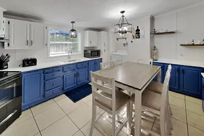 a kitchen with blue cabinets and a wooden table and chairs at Put-in-Bay Island Club #5 in Put-in-Bay