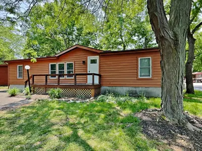 a wooden house with a tree in front of it at Put-in-Bay Island Club #13 in Put-in-Bay