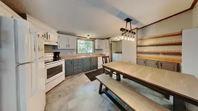 a kitchen with white cabinets and a wooden table at Put-in-Bay Island Club #71 in Put-in-Bay