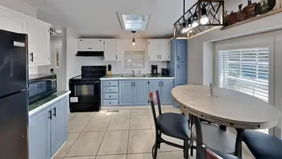 a kitchen with blue cabinets and a table with chairs at Put-in-Bay Island Club #101 in Put-in-Bay