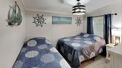 a bedroom with two beds and a clock on the wall at Put-in-Bay Island Club #104 in Put-in-Bay