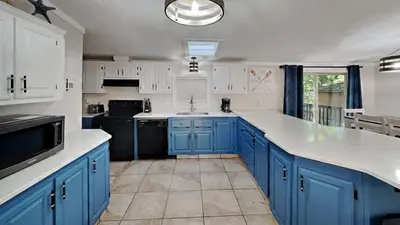 a kitchen with blue cabinets and a black appliance at Put-in-Bay Island Club #104 in Put-in-Bay
