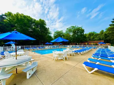 a pool with blue umbrellas and white chairs and tables at Put-in-Bay Island Club #66 in Put-in-Bay