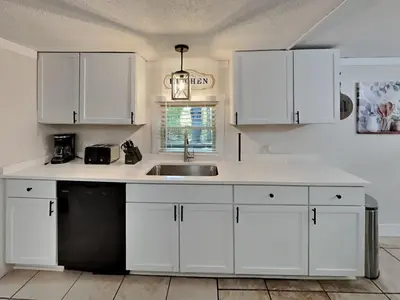 a kitchen with white cabinets and a sink at Put-in-Bay Island Club #66 in Put-in-Bay