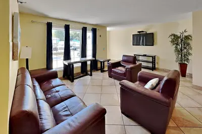 a living room with leather couches and a table at Put-in-Bay Poolview Condo #3 in Put-in-Bay