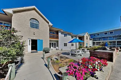 a building with a patio and flowers in front of it at Put-in-Bay Poolview Condo #3 in Put-in-Bay