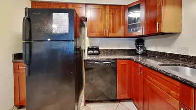 a kitchen with a black refrigerator and a dishwasher at Put-in-Bay Poolview Condo #4 in Put-in-Bay