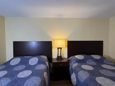 a hotel room with two beds and a lamp at Put-in-Bay Poolview Condo #5 in Put-in-Bay