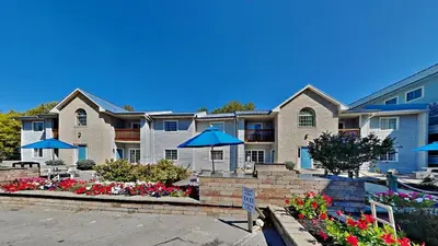 a large apartment building with umbrellas in a parking lot at Put-in-Bay Poolview Condo #5 in Put-in-Bay