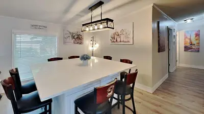 a kitchen and dining room with a white counter and chairs at Put-in-Bay Island Club #4 in Put-in-Bay