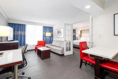 a hotel room with a bed and a living room at Holiday Inn Weirton-Steubenville Area in Weirton