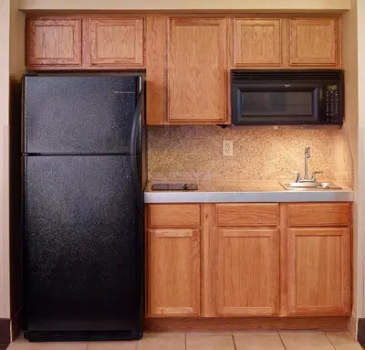 a kitchen with a black refrigerator and a sink at LivINN Hotel Cincinnati North/ Sharonville in Sharonville