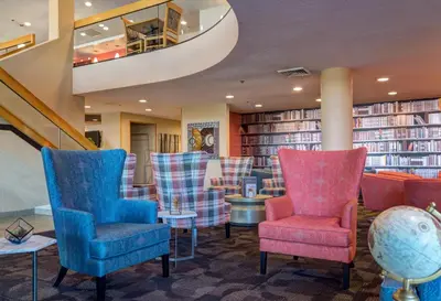 a library with chairs and tables and books at LivINN Hotel Cincinnati North/ Sharonville in Sharonville