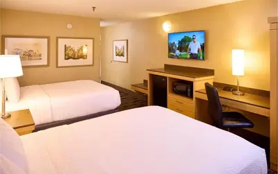 a hotel room with two beds and a desk and a tv at LivINN Hotel Cincinnati North/ Sharonville in Sharonville
