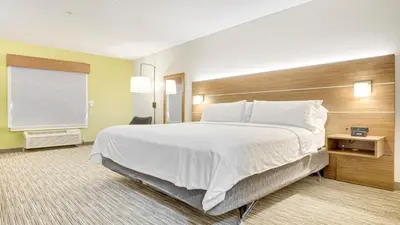 a hotel room with a large bed and a window at Holiday Inn Express Hotel & Suites Portland by IHG in Portland
