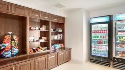 a store room with a refrigerator and shelves with food at Holiday Inn Express Hotel & Suites Portland by IHG in Portland