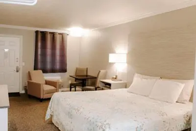 a hotel room with a bed and a chair and a desk at Berlin Village Inn in Berlin