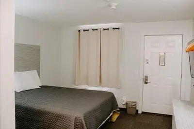 a bedroom with a bed and a window and a door at Berlin Village Inn in Berlin
