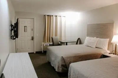 a hotel room with two beds and a door at Berlin Village Inn in Berlin