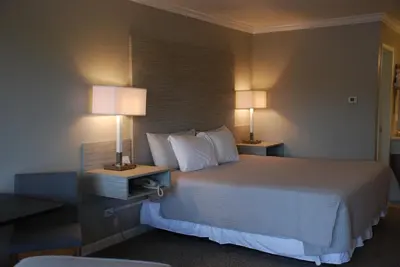 a hotel room with a bed and two lamps at Berlin Village Inn in Berlin