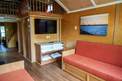 a living room with a red couch and a tv at Cedar Point's Lighthouse Point in Sandusky